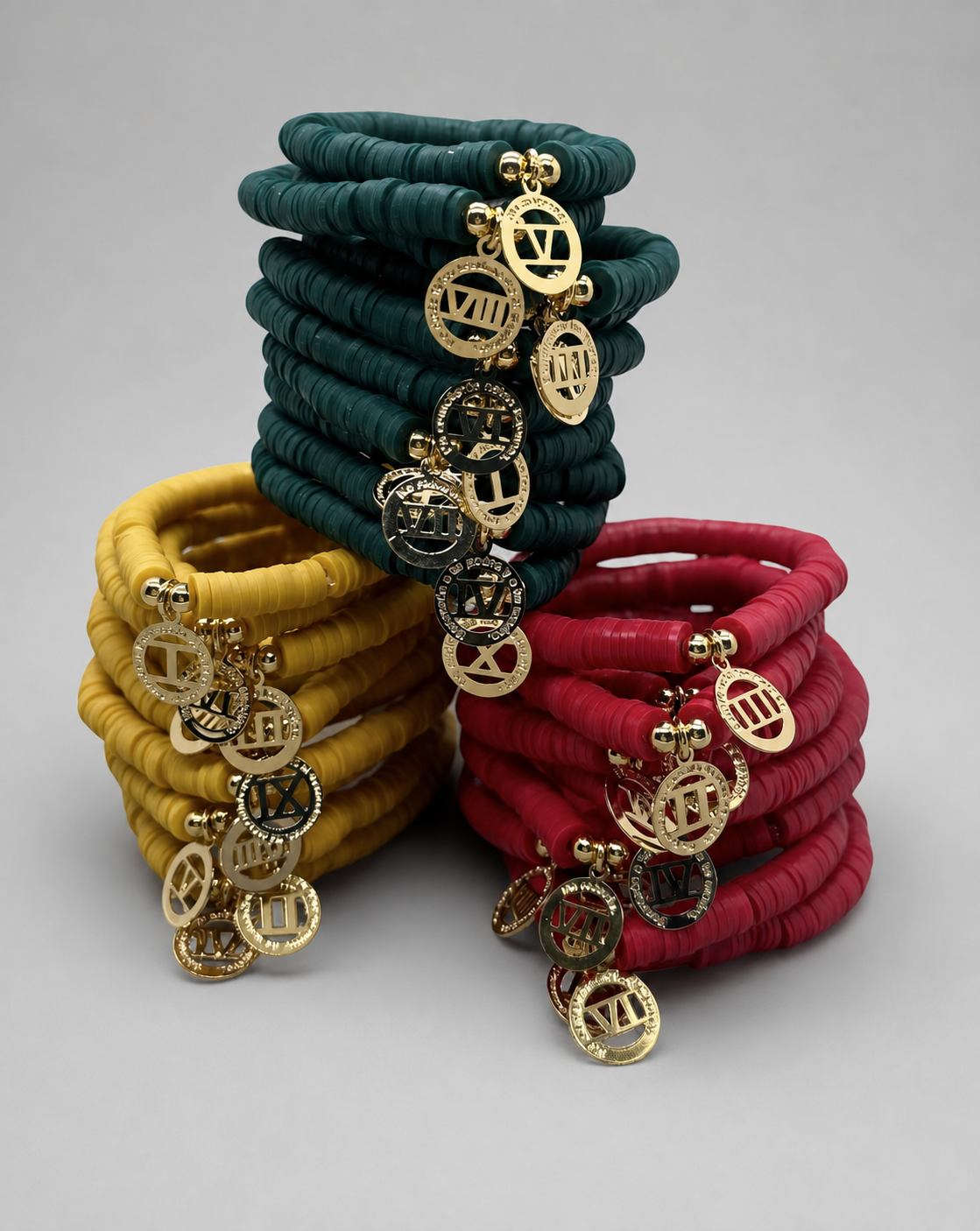 Set Diez Mandamientos — brazaletes heishi en teal, amarillo mostaza y rojo con dijes dorados en números romanos